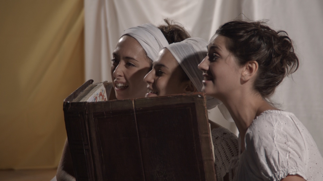 Three performers peering over large book at audience