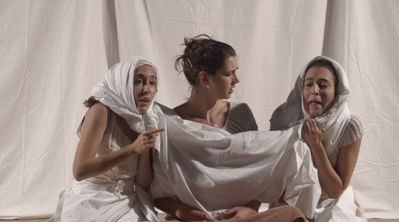 Performers using white sheet to imitate wimple