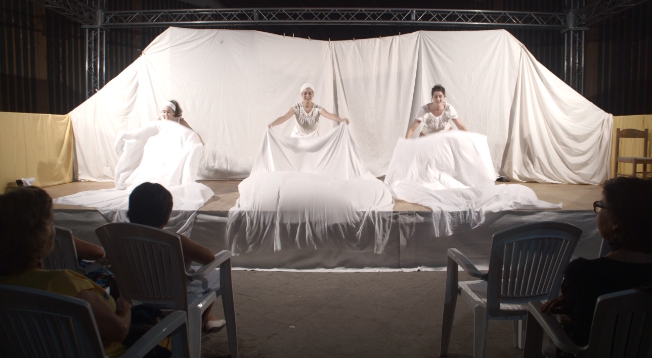 Performers using white sheets with physical theatre