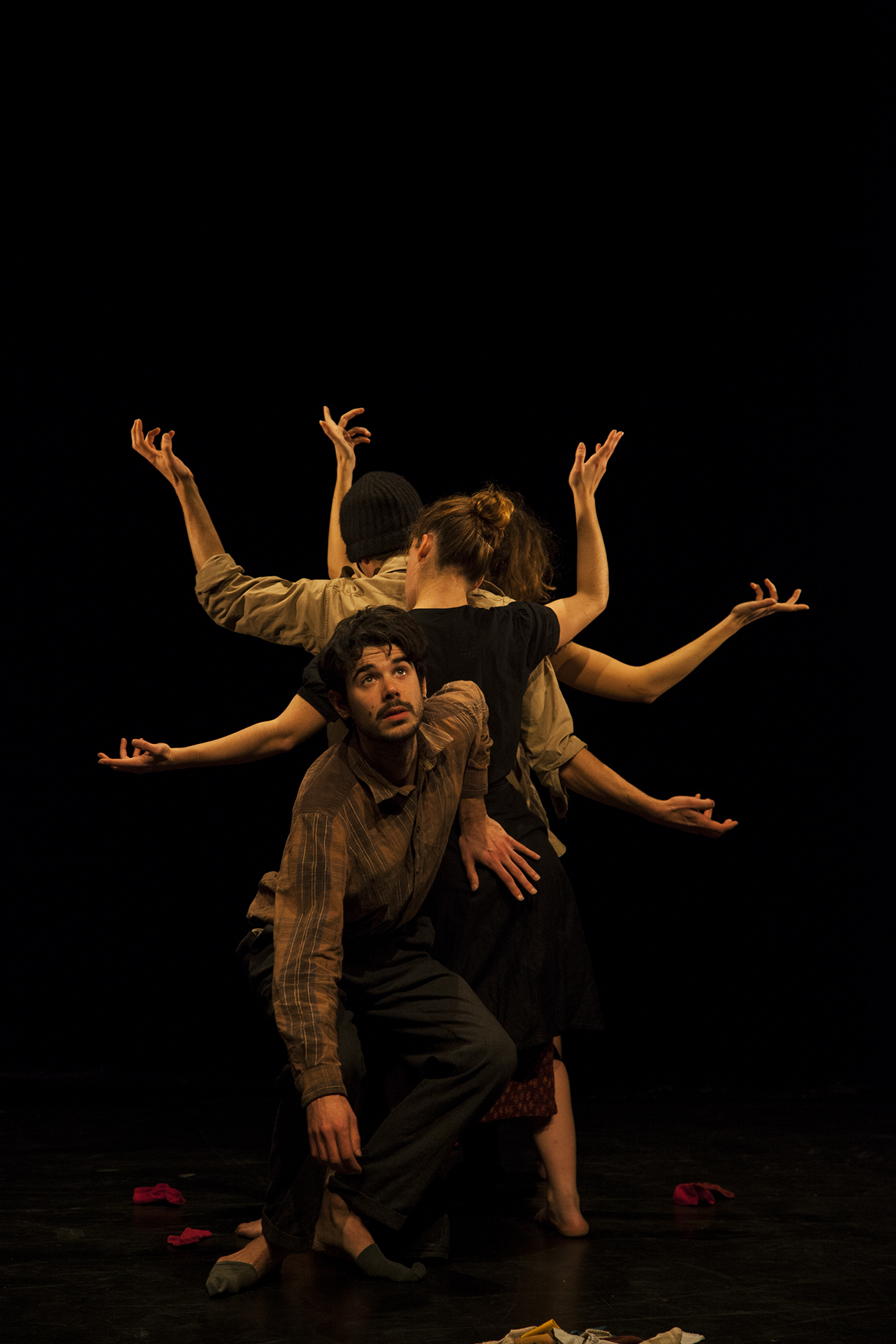 Performer looking up with other performers' arms outstretched behind
