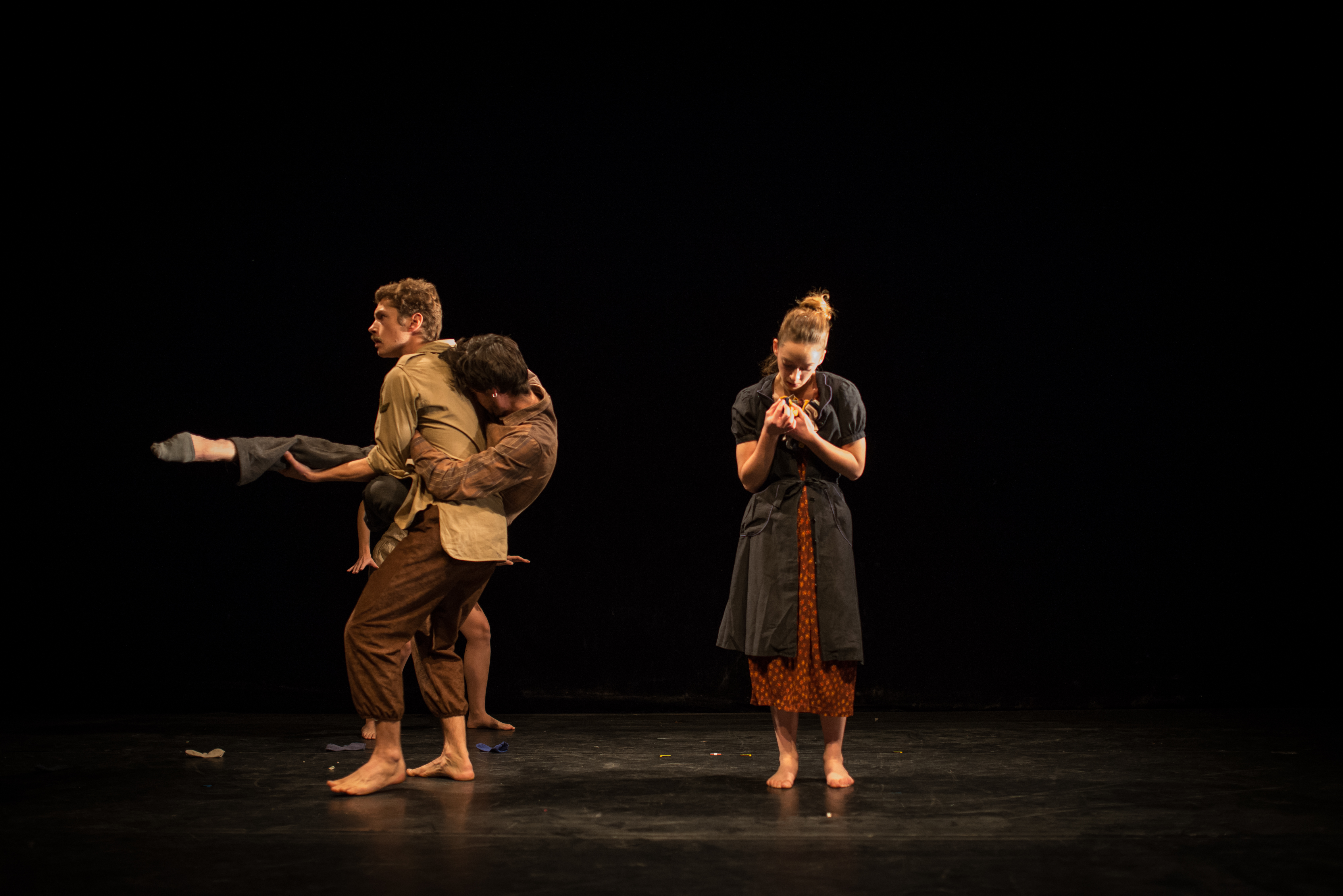 Performers in various physical poses on stage