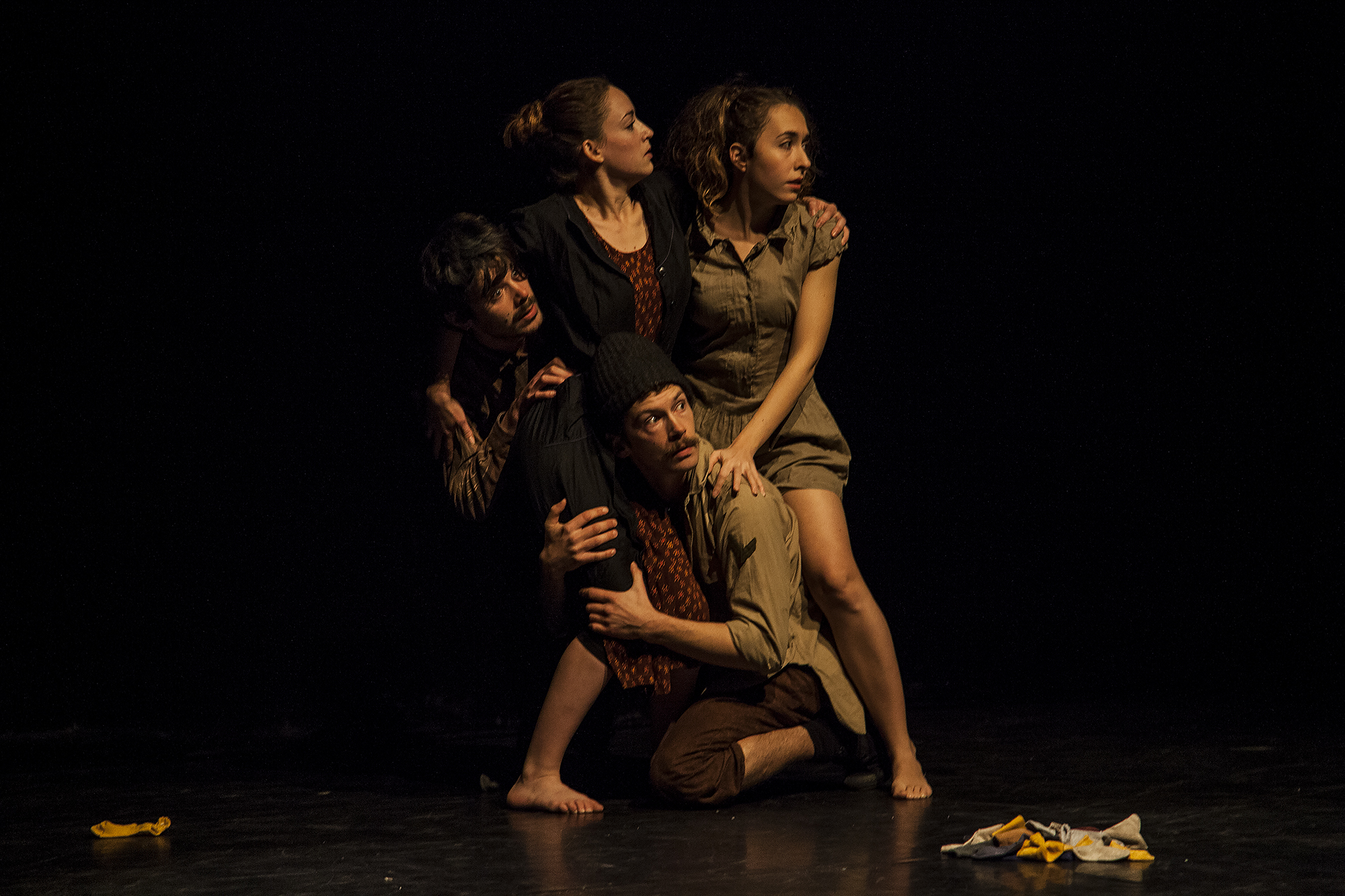 Performers huddled and looking worriedly off stage