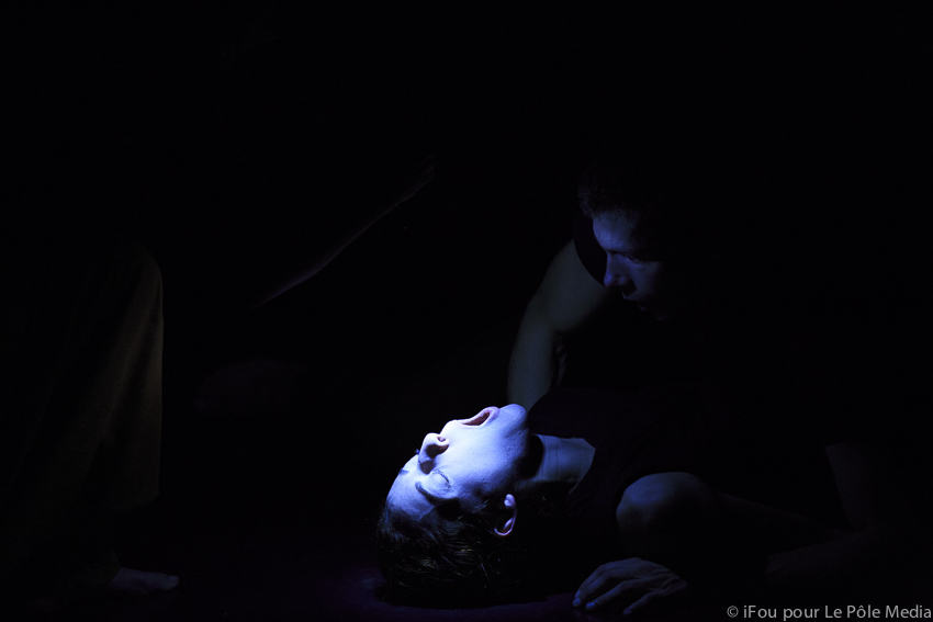 Tightly lit face of performer, eyes closed and mouth wide open