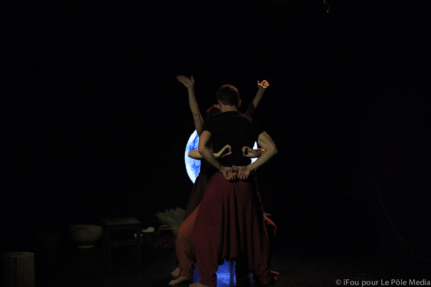 Performers entangled to show animal with their limbs and hands as facial features