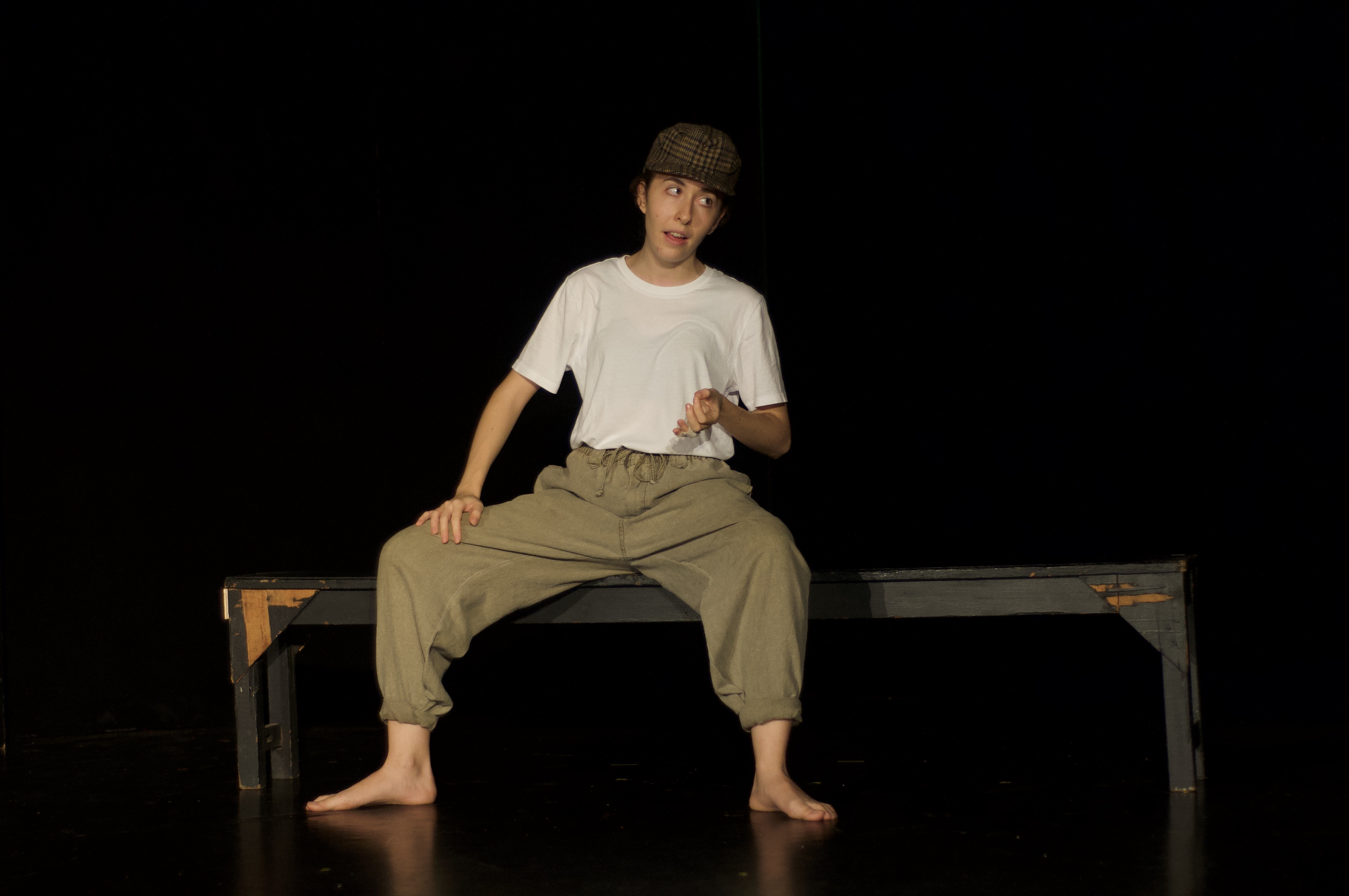 Giorgia sat on bench with hat on with animated expression