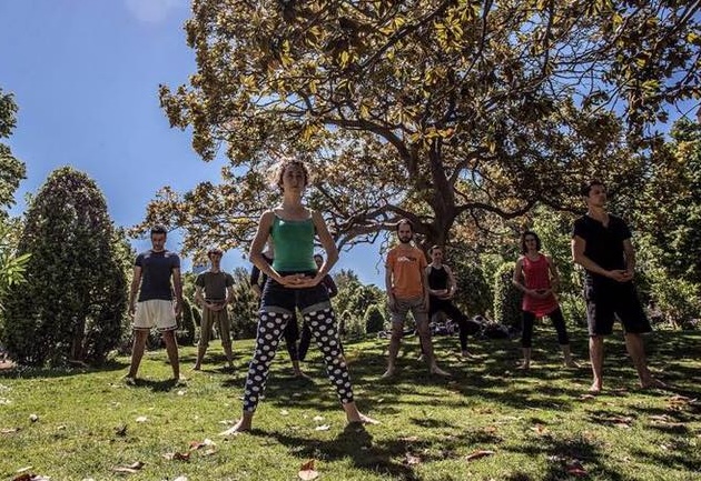 Group in studio, focused in standing stance, one arm and palm forward