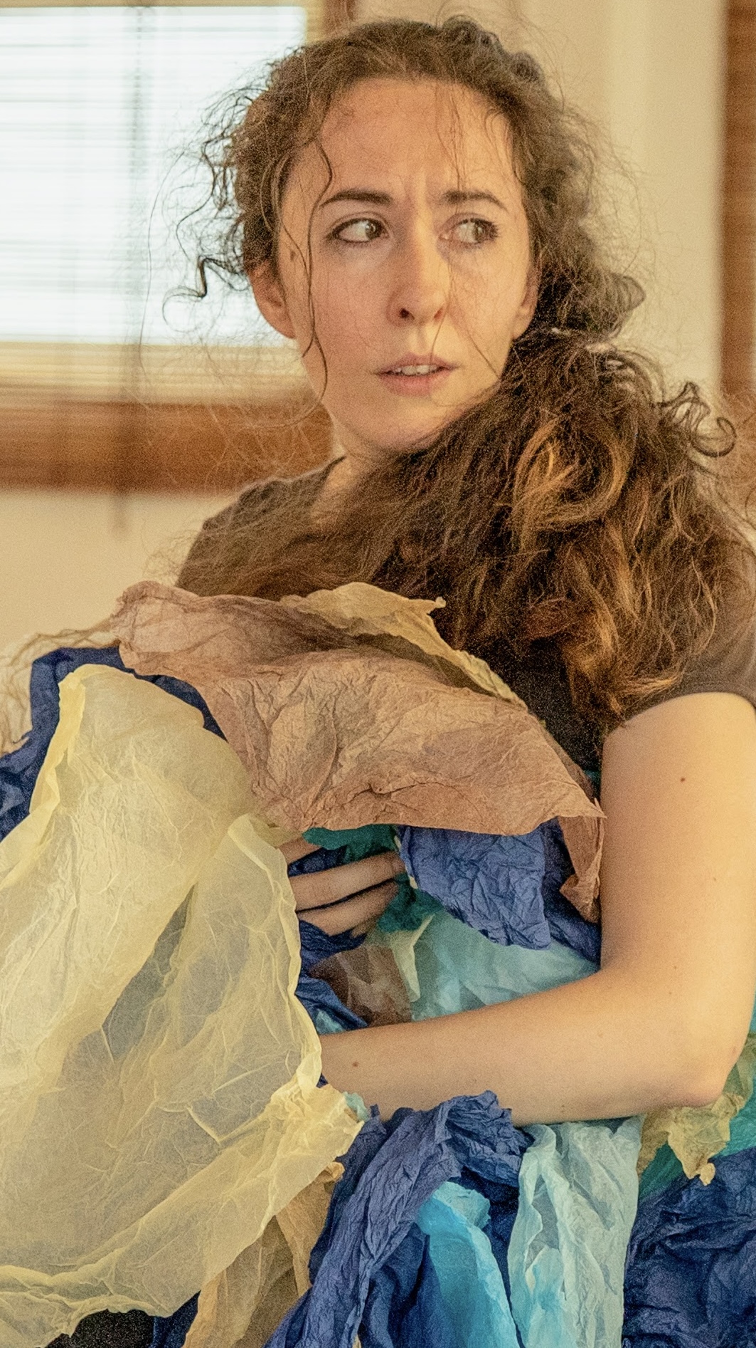 Giorgia on stage crouched with hat, giggling