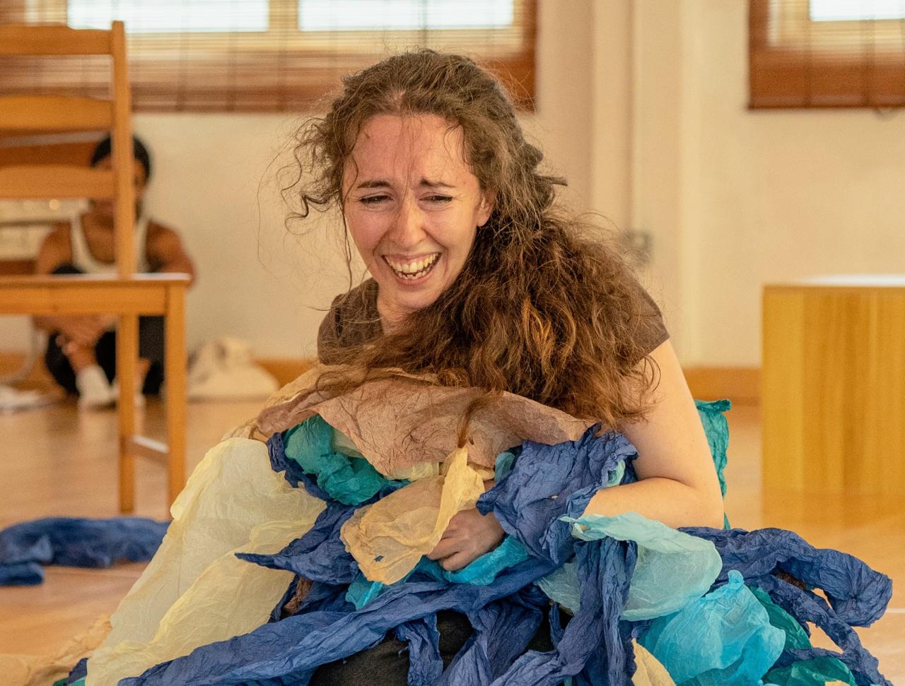 Giorgia on stage crouched with hat, giggling